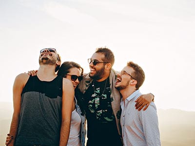 Surround Yourself with Positive People four friends showing optimism in recovery laughing with their arms around one another