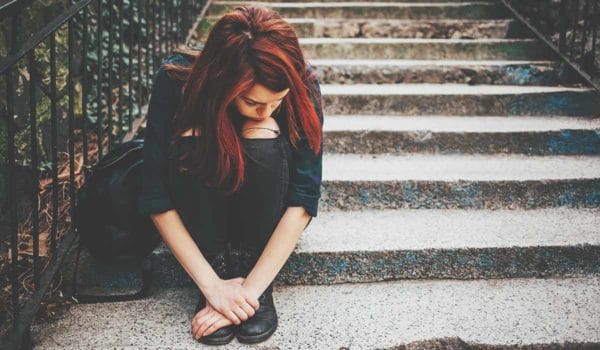 A young woman high on drugs sits alone