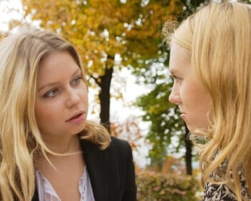 closeup of two young women outdoors in deep conversation