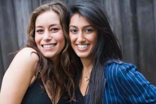 two young women posing together with smiles
