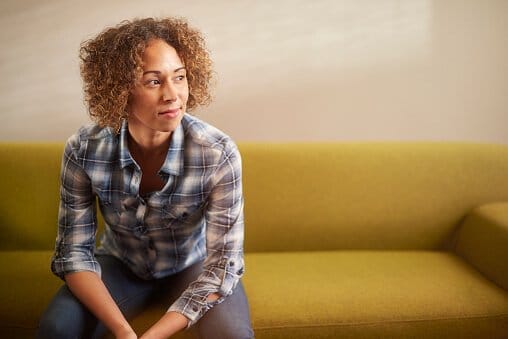 seated woman on couch learning about drug abuse