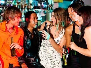 group of young people at a bar drinking and chatting