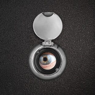 closeup of an eye looking through a peephole
