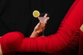 an image of an alcoholic drink placed on the back on an emaciated female body in a tight red dress indicating the dangers of drunkorexia