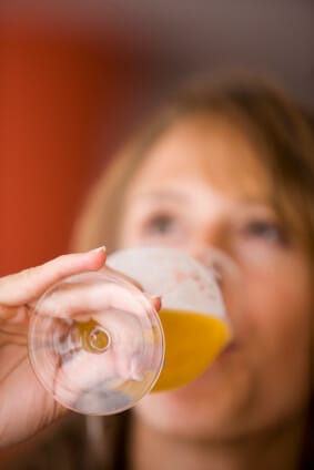 closeup of woman drinking a glass of beer