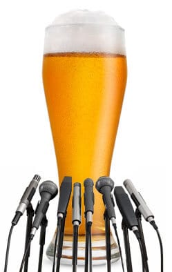 giant glass of beer giving press conference in front of microphones