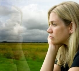 worried woman looking out window into nature as she contemplates the dangers to women in recovery
